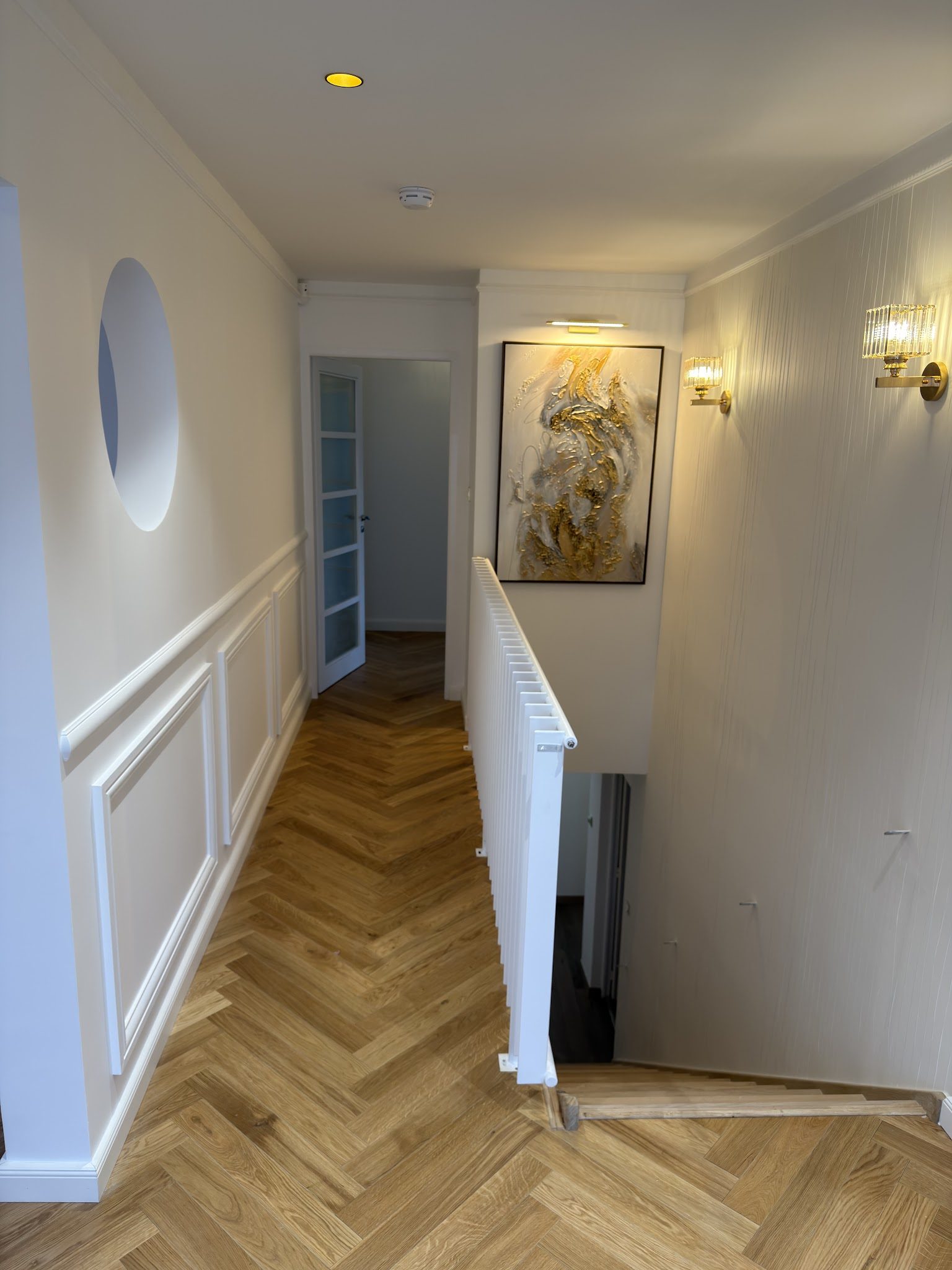 Couloir à soubassement mouluré et parquet en chevron