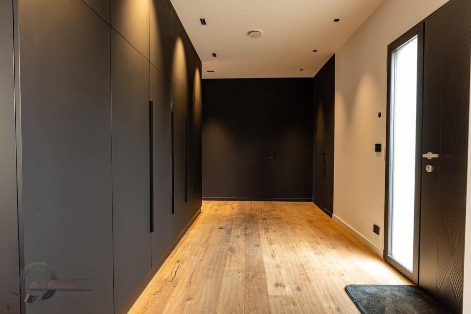 Couloir aux placards noirs toute hauteur et parquet chêne